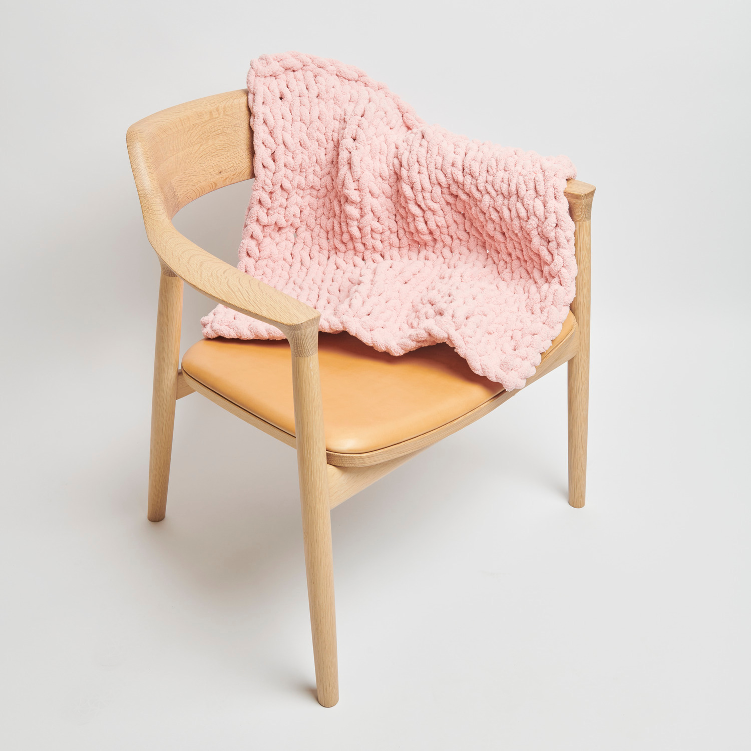 Chenillove Super Big: Weiche rosa Decke von Rico Design auf einem Holzstuhl drapiert, 300g, 36m.