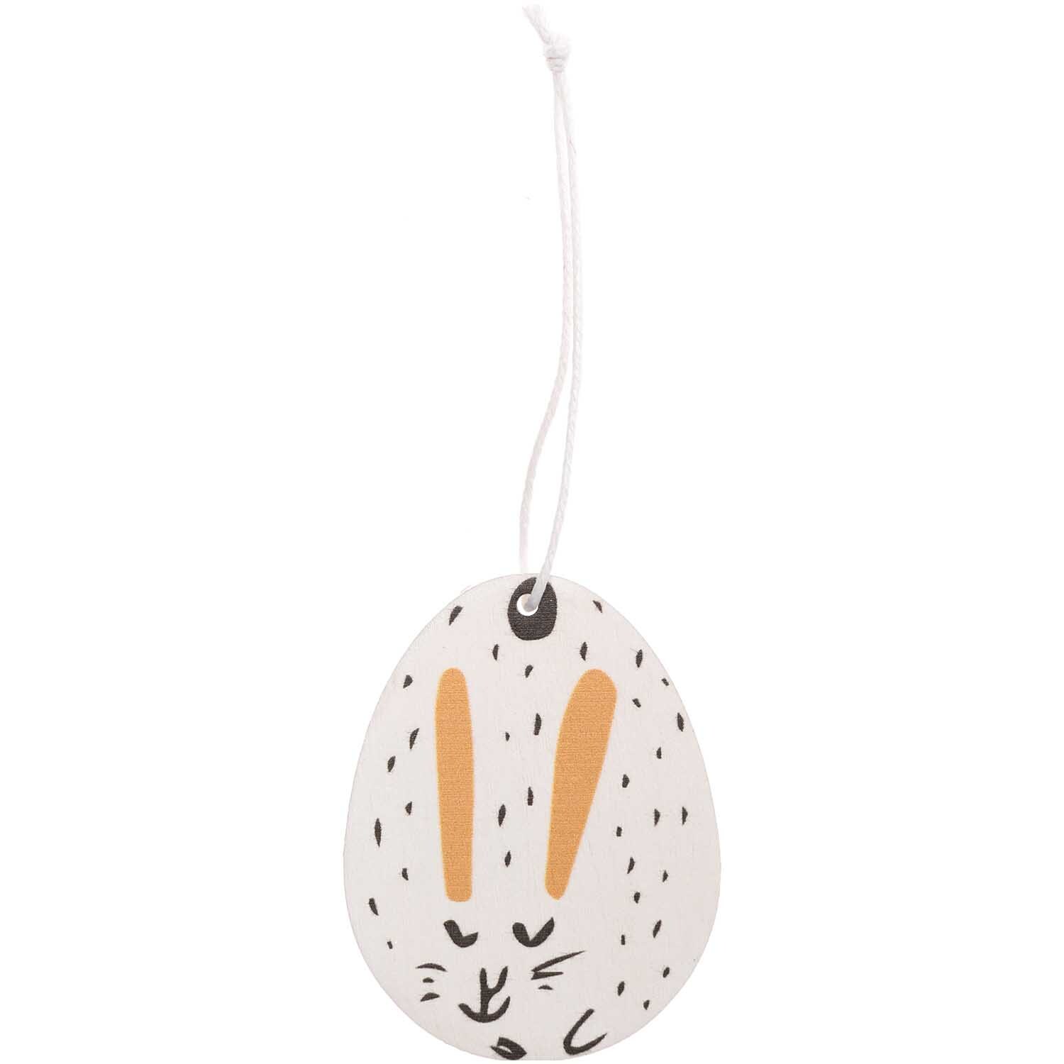 Holzhänger Osterei Hase 1 Stück von Rico Design zeigt ein weißes Ei mit Hasengesicht und Aufhänger.