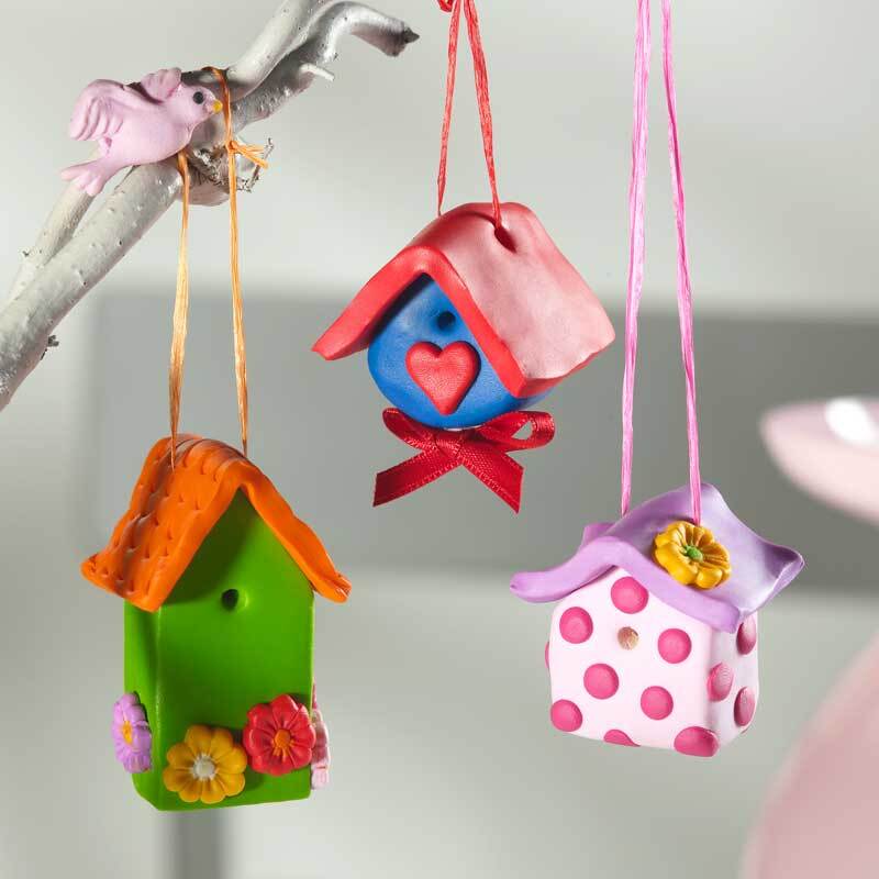 FIMO soft: Drei bunte Vogelhäuschen aus Modelliermasse in verschiedenen Farben, hängend an einem Ast.