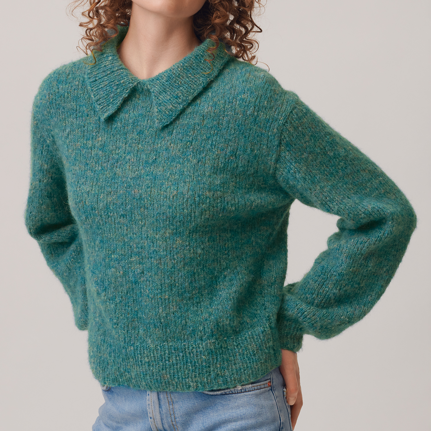 Strickanleitung Kragen-Pulli aus Fashion Skinny Alpaca aran: Frau trägt grünen Pullover mit Kragen, kombiniert mit blauer Jeans.