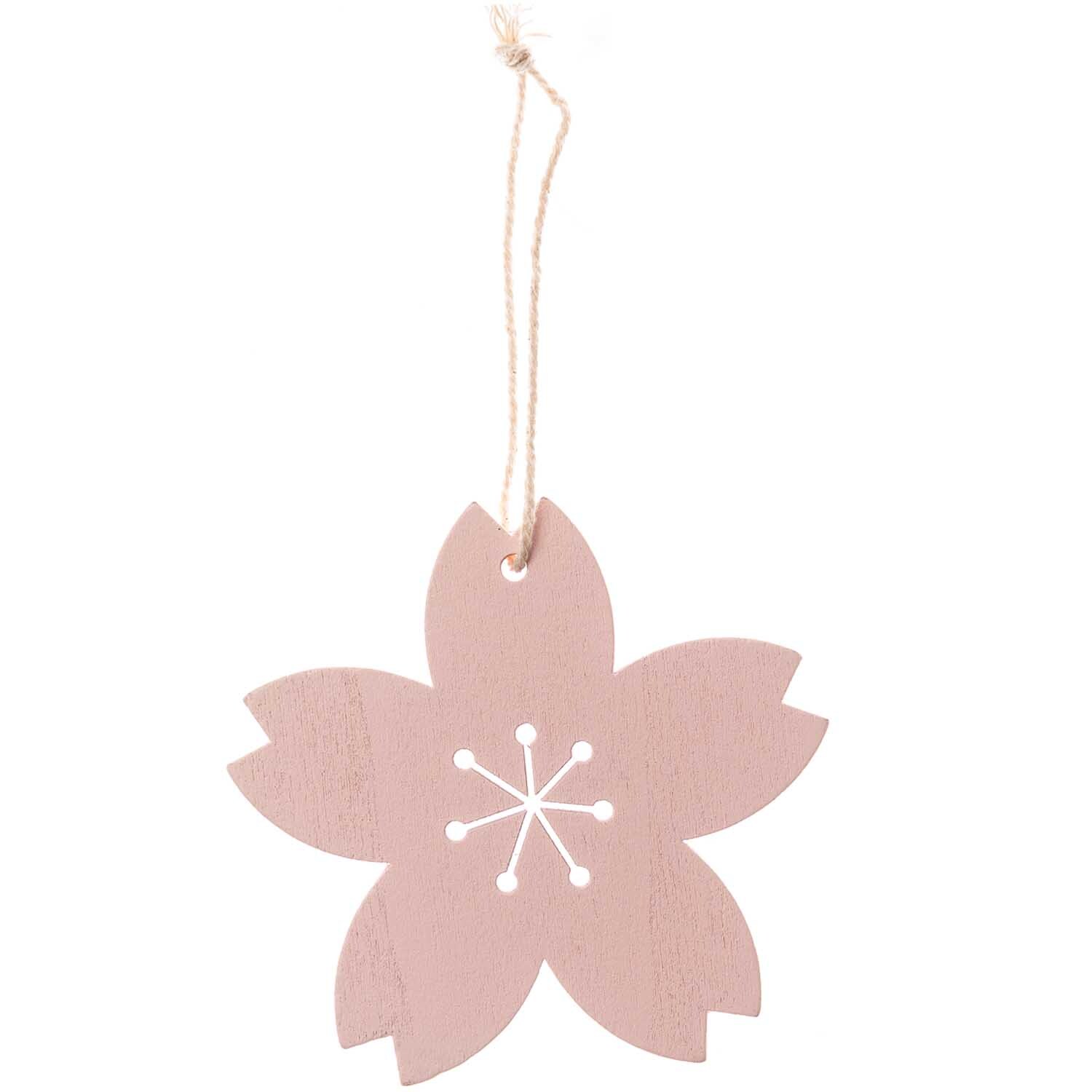 Hänger Blüte puder 1 Stück: Dekorativer Anhänger in Blütenform von Rico Design, aus rosa Holz mit weißem Muster.