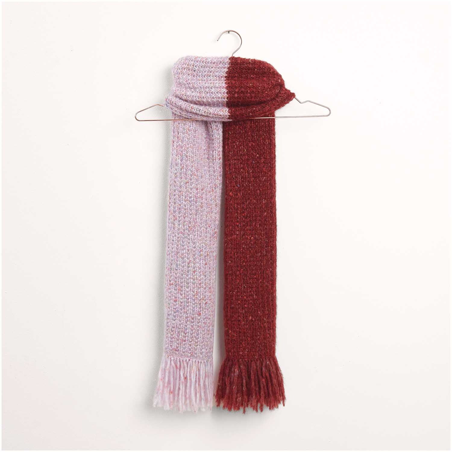 Strickset Schal Modell 28: Zweifarbiger Schal in Rot und Rosa, aufgehängt an einem Kleiderbügel.
