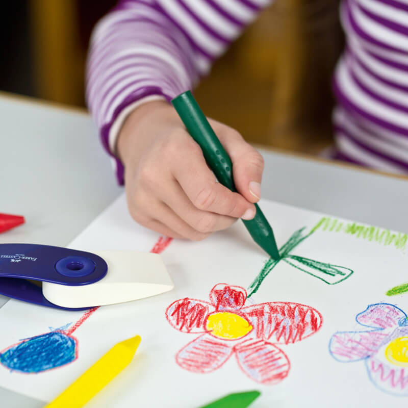 Grip radierbare Kreide Jumbo: Kind malt mit mehrfarbiger Kreide von Faber Castell bunte Blumen auf Papier.