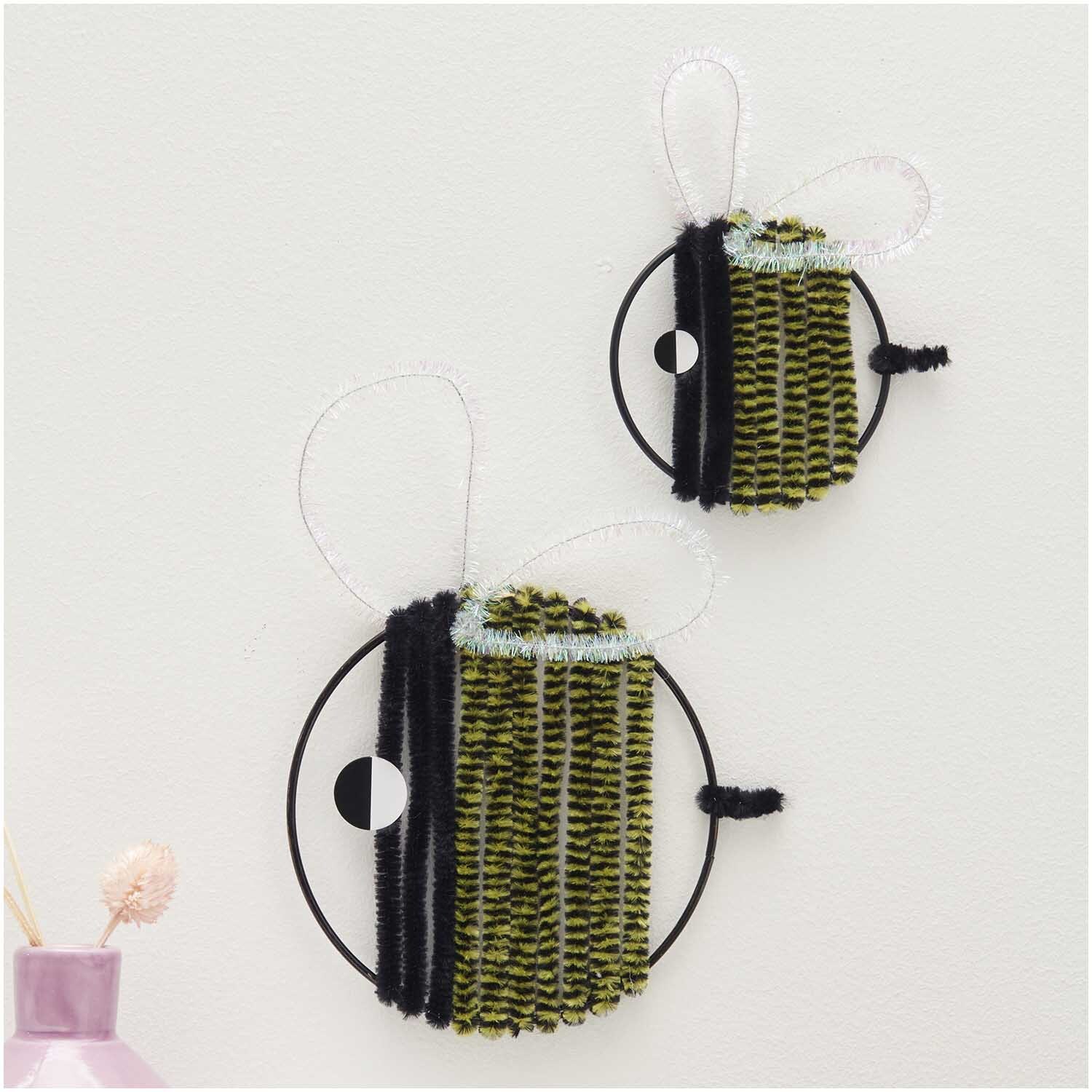 Chenilledraht-Mix 50cm 10 Stück Bienen Mix von Rico Design: Zwei dekorative Bienen aus Chenilledraht in Schwarz und Gelb an einer Wand.