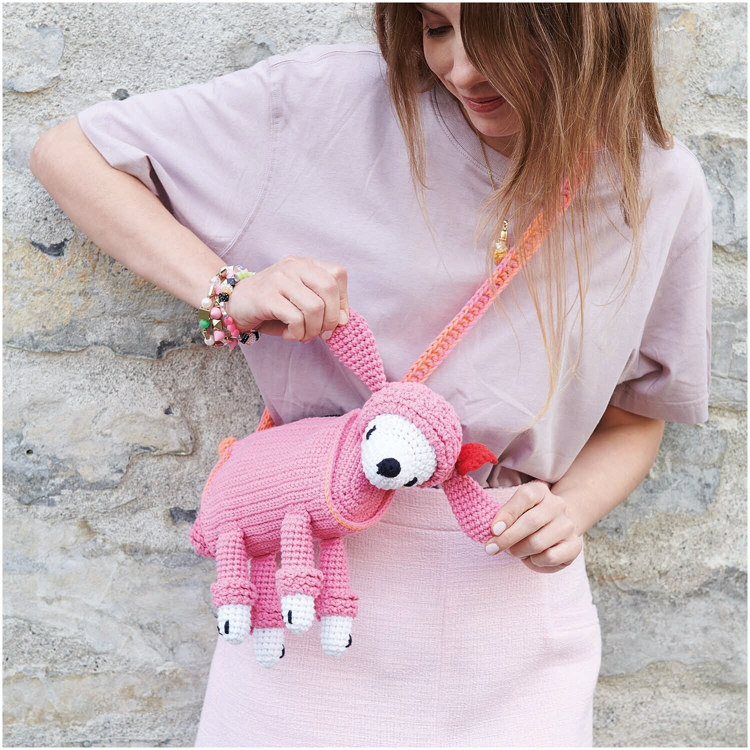 Creative Ricorumi Neon dk: Frau mit rosa gestrickter Faultiertasche aus Rico Design Garn in Neon-Orange.