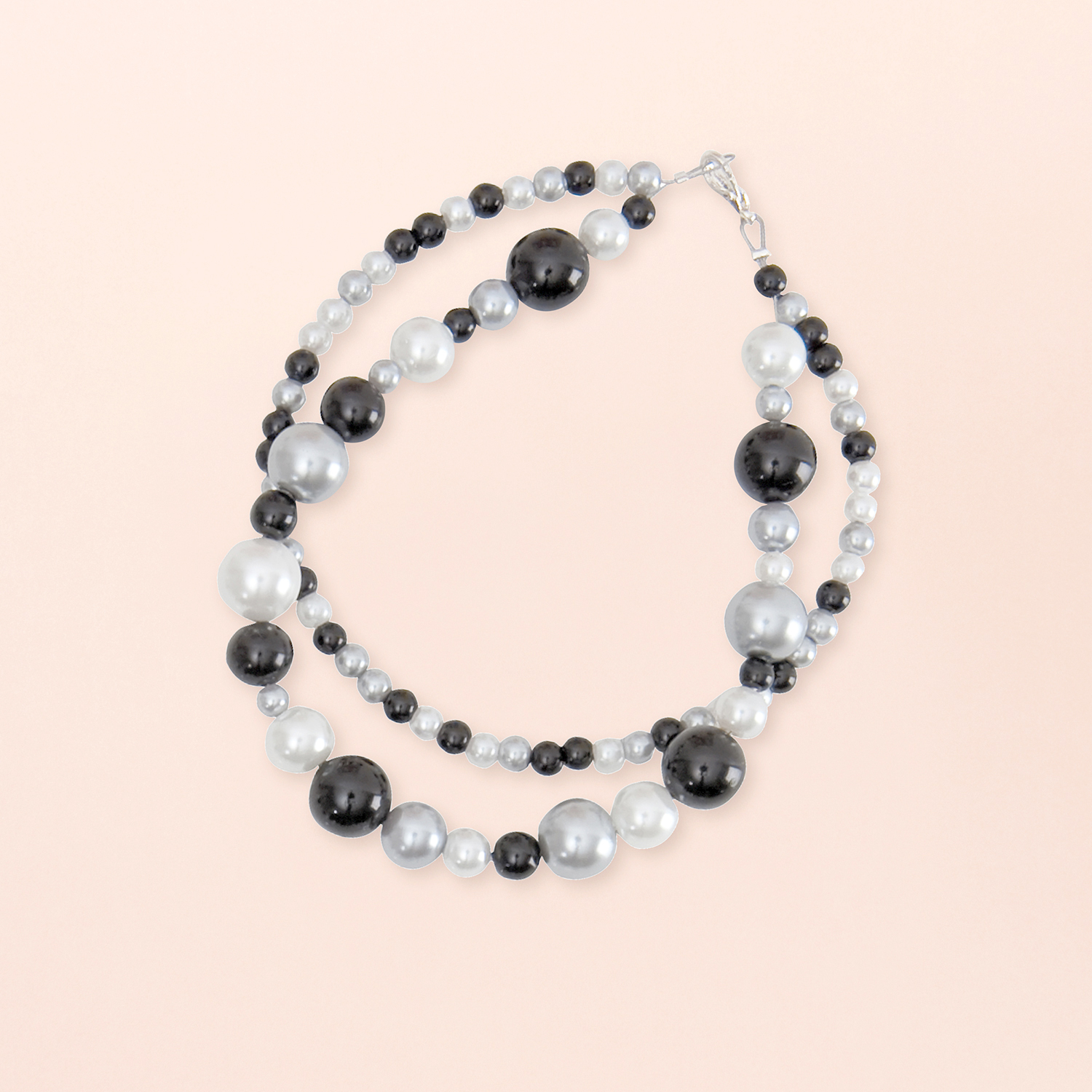 Anleitung Renaissance Perlenset Armband basteln: Elegantes Armband mit schwarzen und weißen Perlen auf hellem Hintergrund.