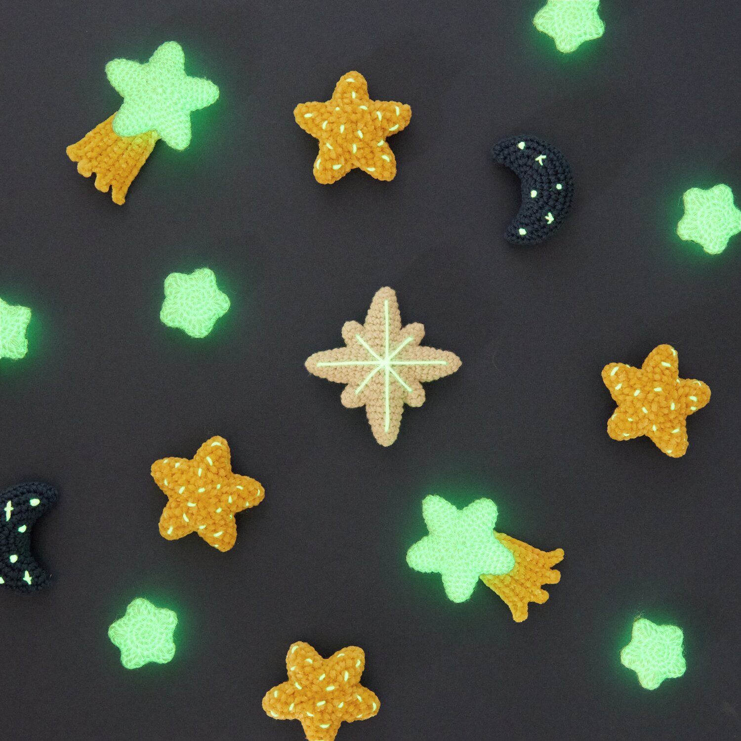 Ricorumi Glow In The Dark dk: Leuchtende Häkelsterne und Monde auf schwarzem Hintergrund, ideal für kreative Projekte.