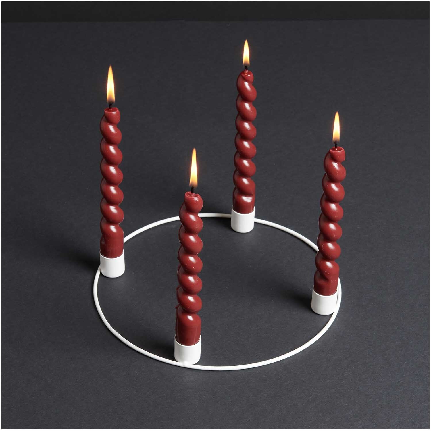 Metallring Adventskranz Ø 25cm mit vier brennenden, gedrehten Kerzen auf schwarzem Hintergrund.