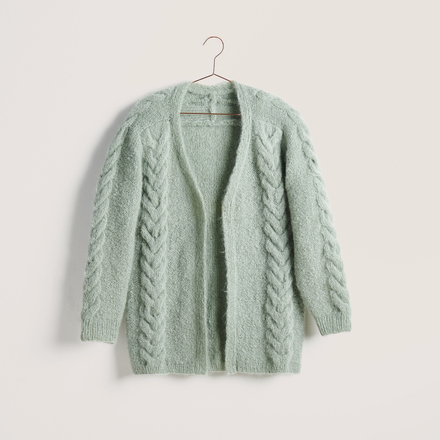 Jubiläums-Strickset Jacke Modell 13 in lindgrün aus Fashion Mohair Merino Chunky, präsentiert auf einem Kleiderbügel.