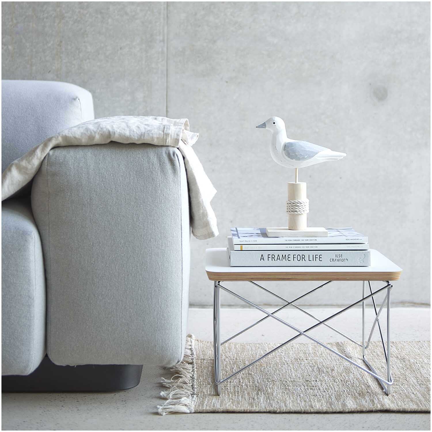 Aufsteller Möwe grau-weiß 20x8x25cm auf modernem Tisch neben grauem Sofa, dekoriert mit Büchern.