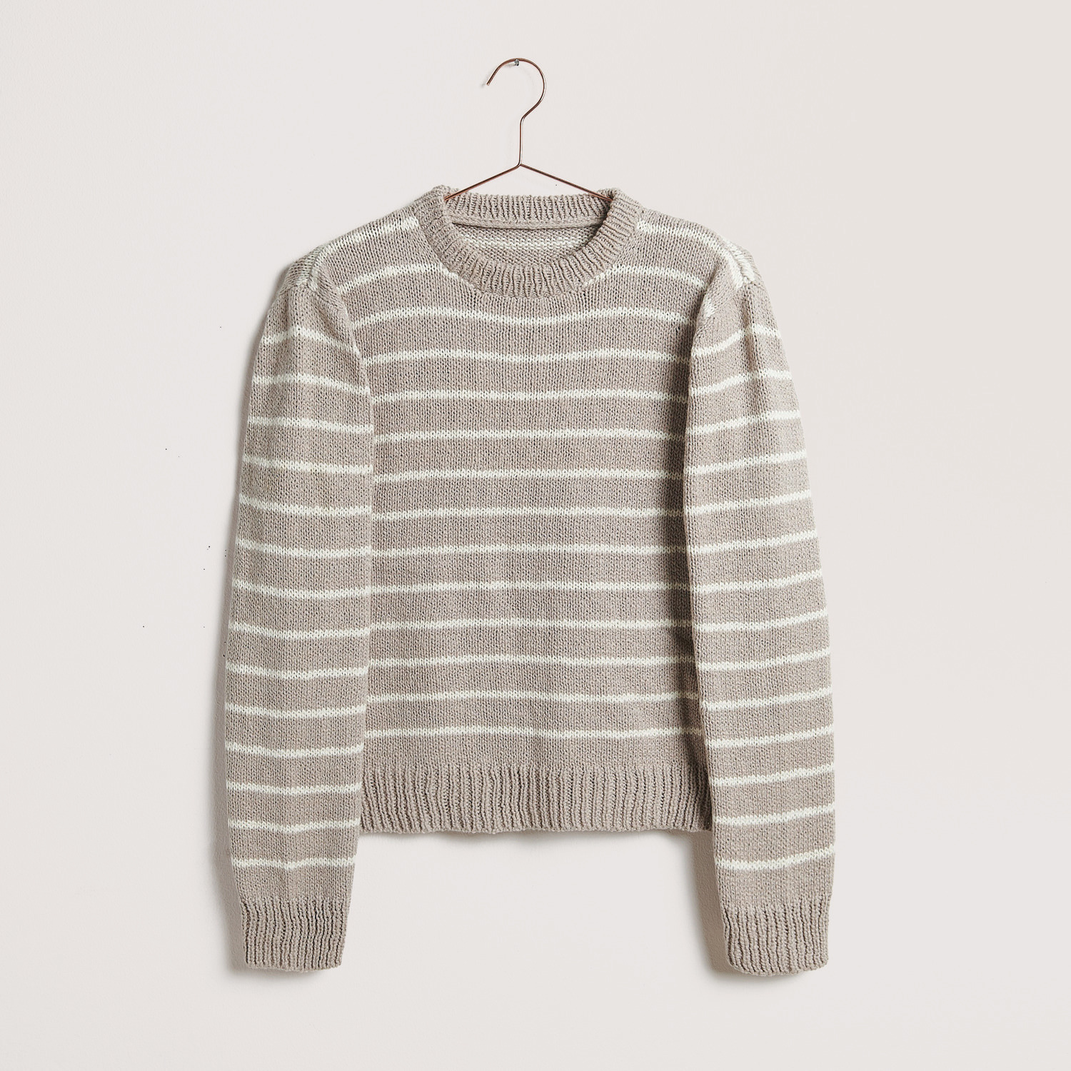 Gestreifter Pullover auf grauem Hintergrund – zum Strickset