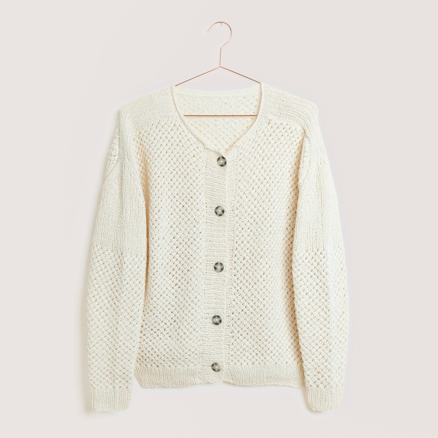 Strickset Jacke Modell 17 aus Made by Me Nr. 18, cremefarbene Strickjacke mit Knöpfen, präsentiert auf einem Kleiderbügel.