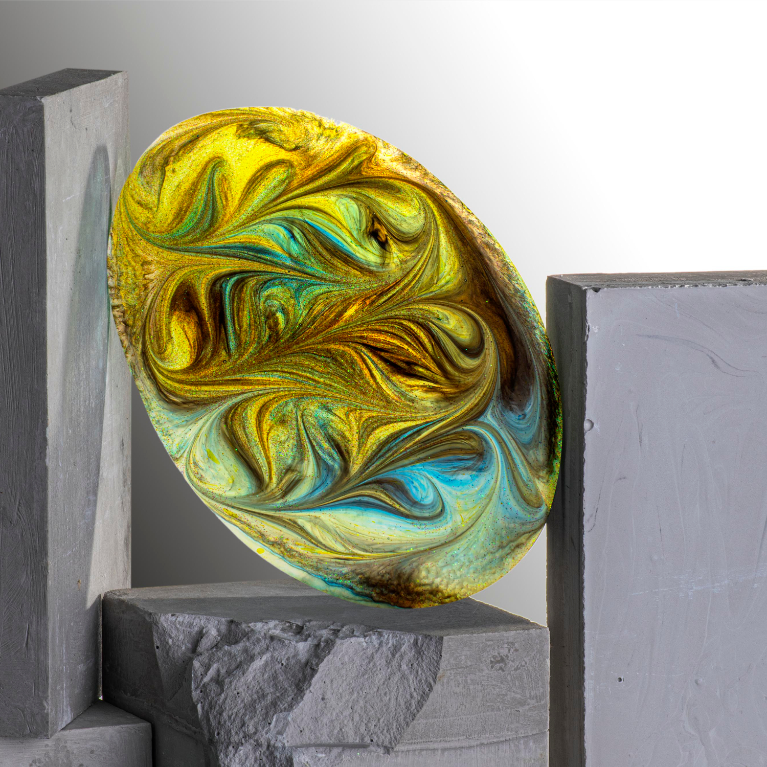 Silikon Farbmischer, kunstvoll gestaltet in Gelb und Blau, präsentiert auf grauen Blöcken.