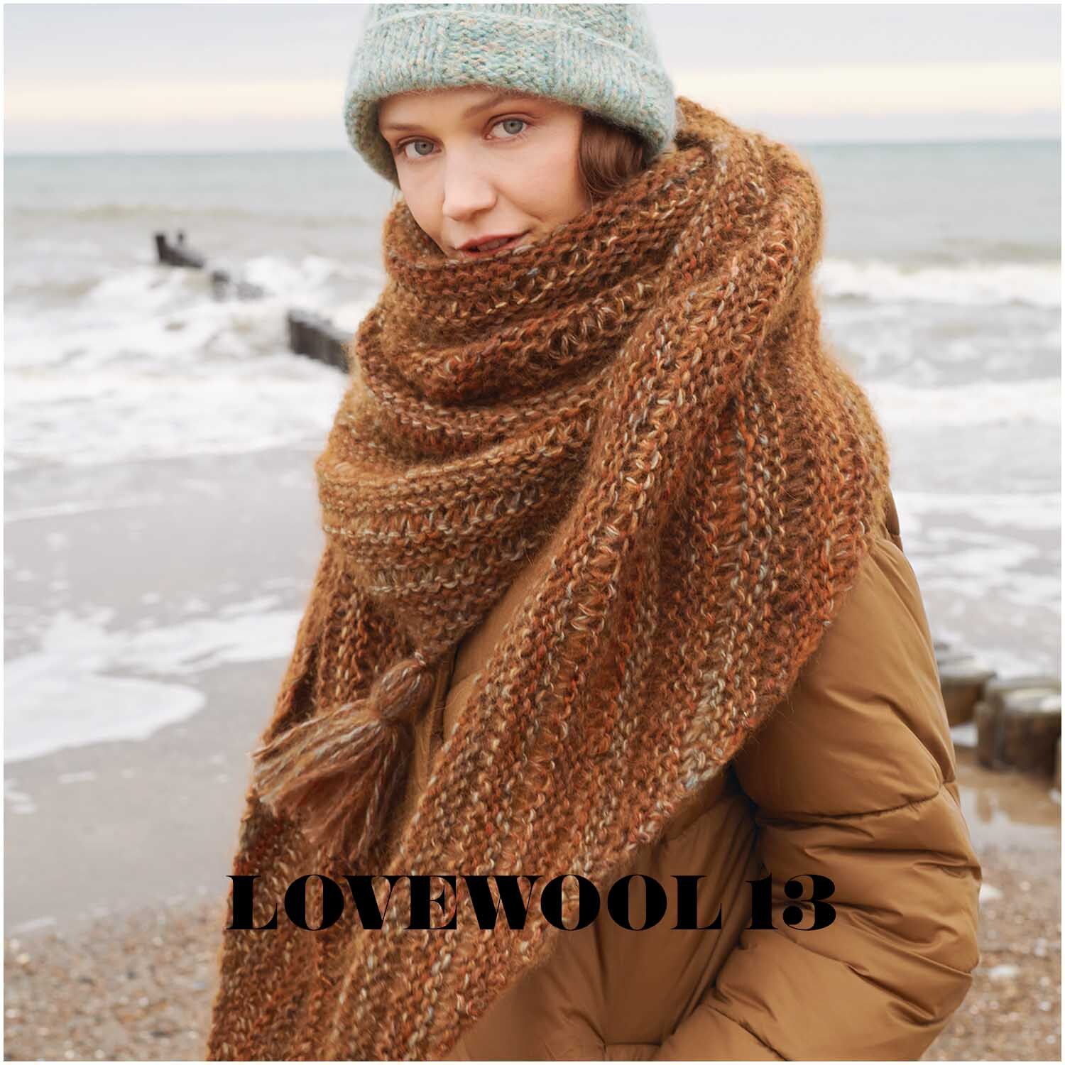 Creative Mohair Melange Schal in Rost von Rico Design, getragen von Frau am Strand bei kühlem Wetter.