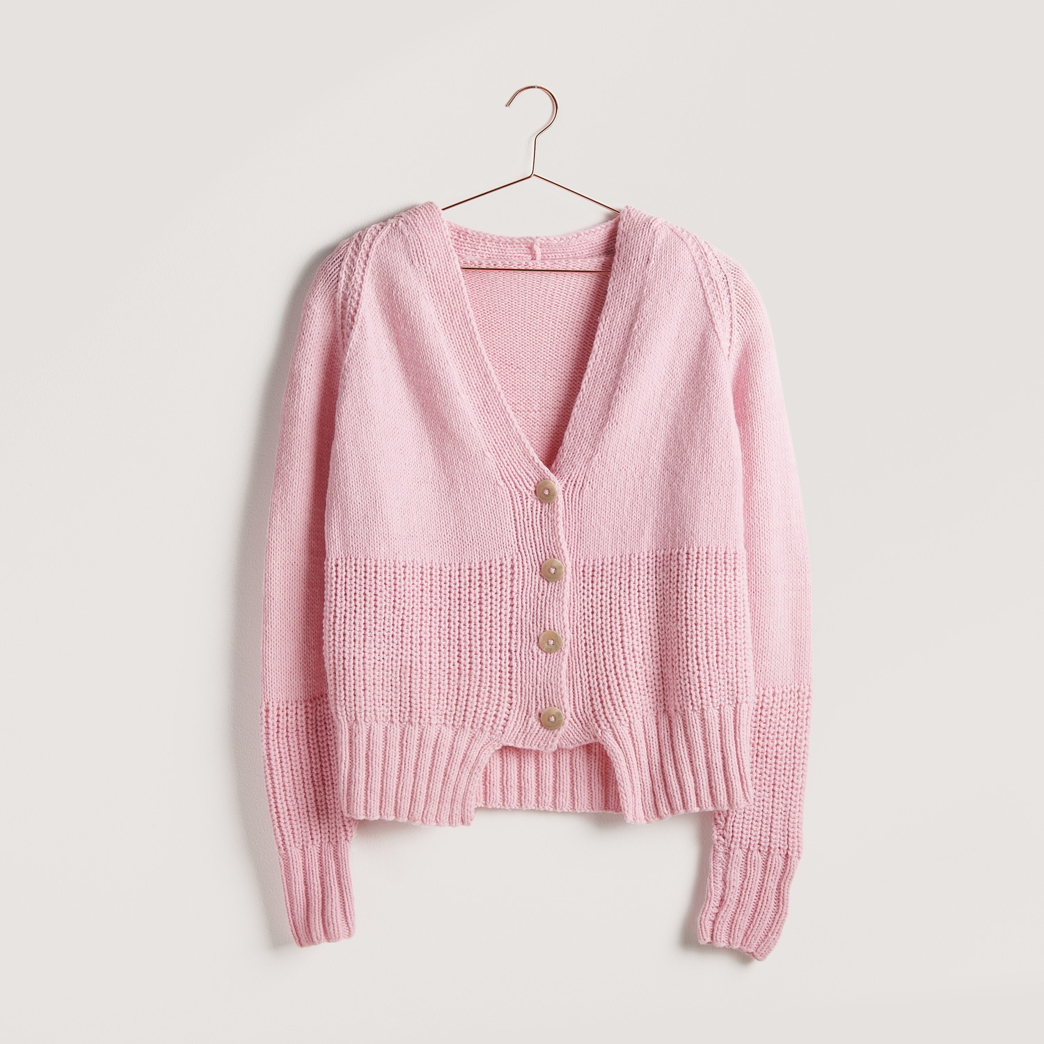 Strickset Jacke Modell 06 aus Vegan Cashmere, rosa, von Rico Design, auf einem Kleiderbügel.