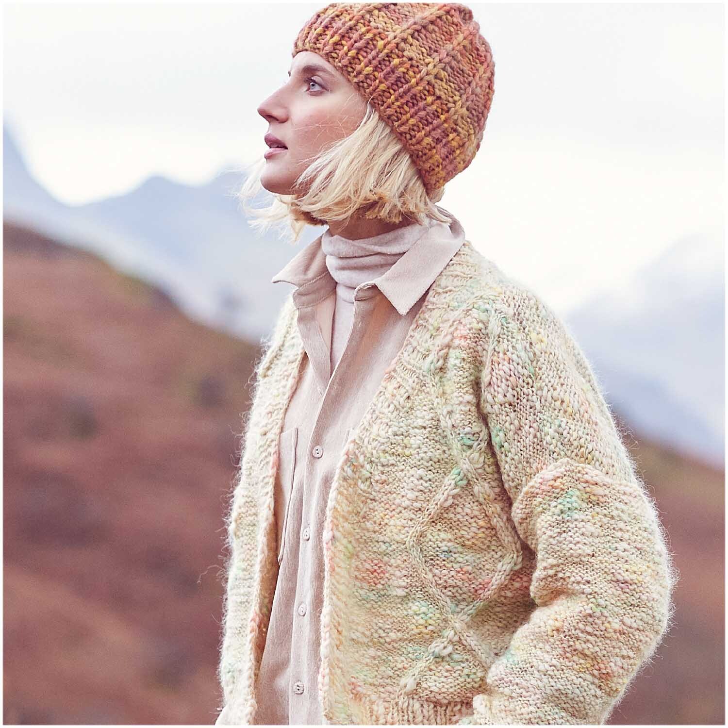 Creative Smile: Frau in gestrickter Mütze und Strickjacke von Rico Design in natürlicher Umgebung.