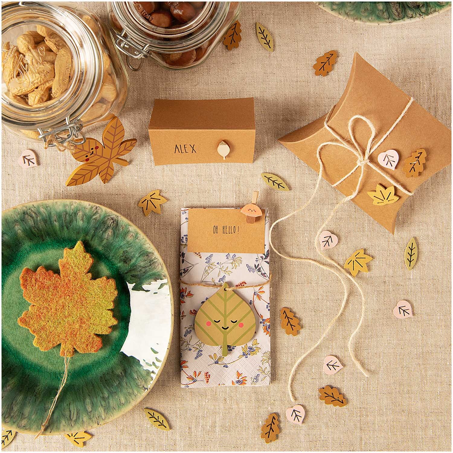 Filzhänger Herbstblatt 9x10cm auf einem Tisch mit herbstlichen Dekorationen und Geschenkverpackungen.