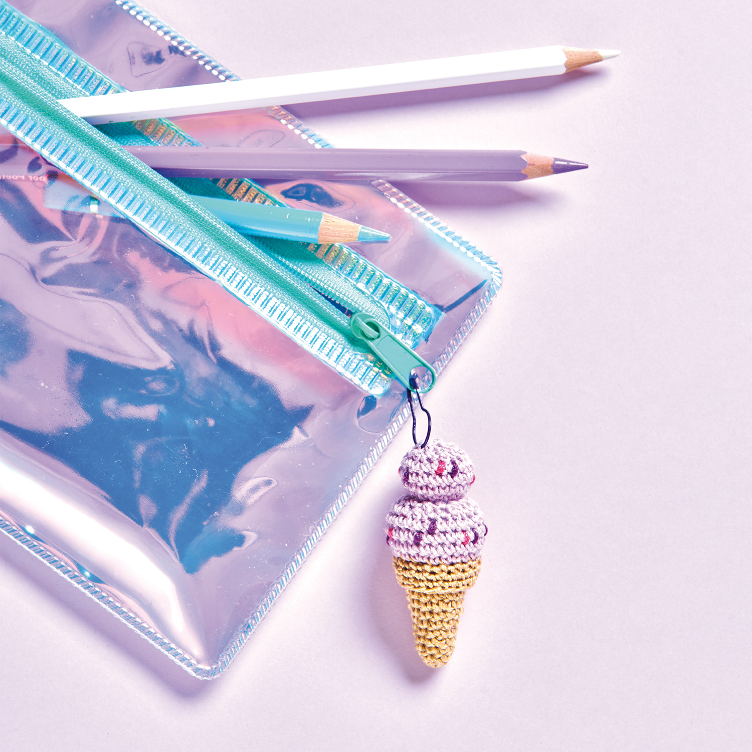 Häkelanleitung Eisanhänger aus Rico Essentials Crochet: Ein gehäkelter Eisanhänger an einer schimmernden Tasche mit Bleistiften.