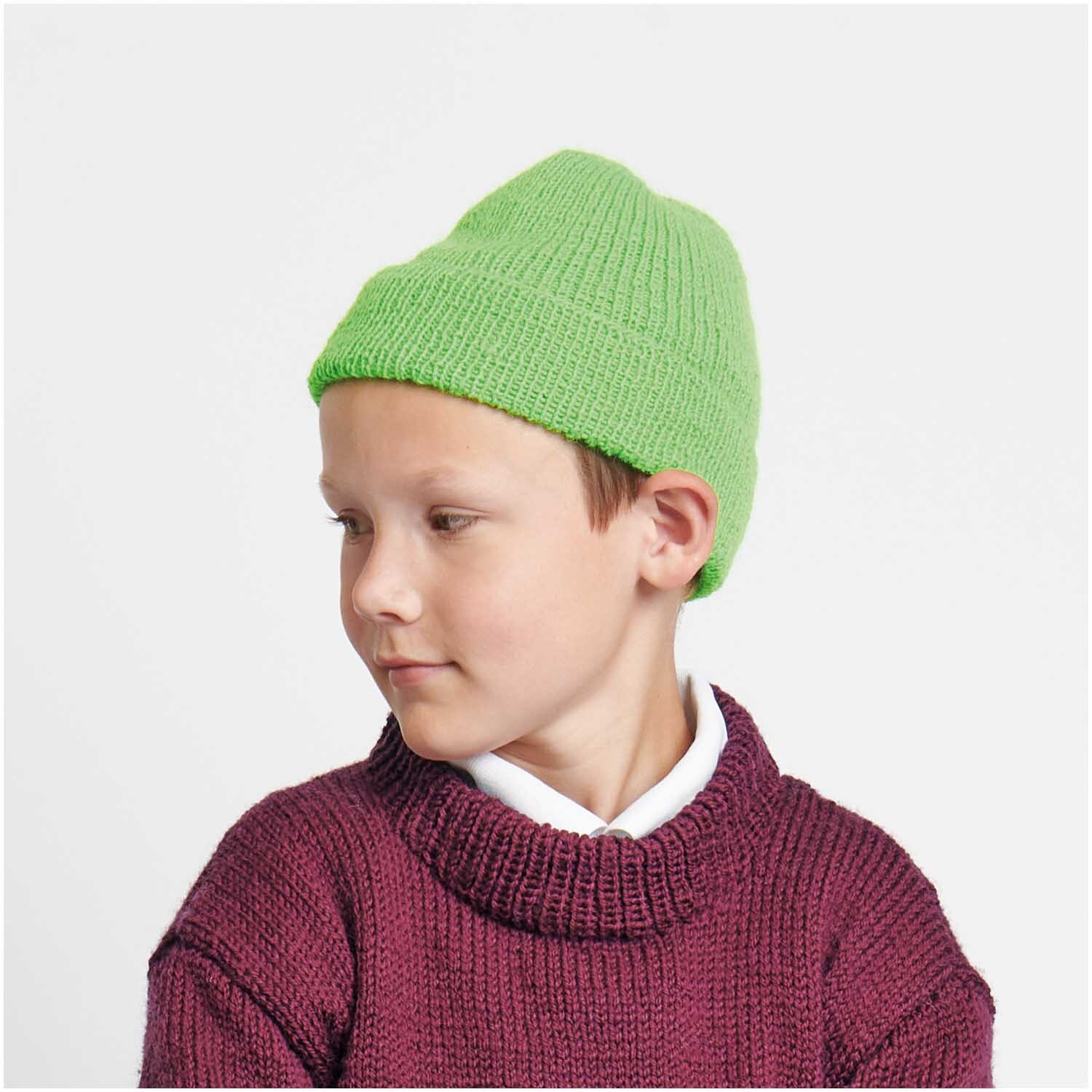 Socks Neon 4-fädig: Kind mit grünem Strickmütze von Rico Design, trägt weinroten Pullover.