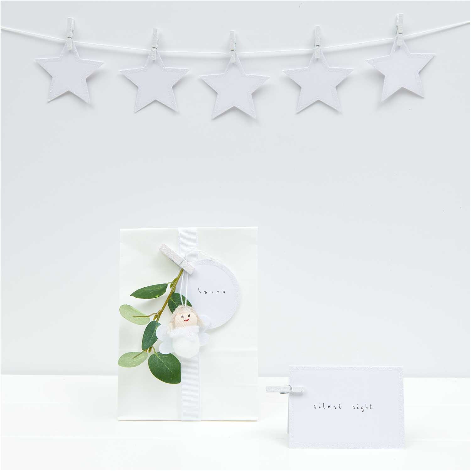 Paper Poetry Papieranhänger Stern in Weiß-Glitter, dekorativ an einer Schnur aufgehängt, ideal für festliche Anlässe.