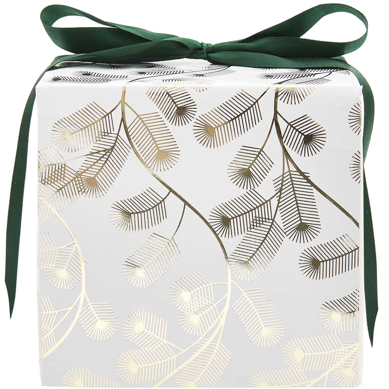 Paper Poetry Geschenkpapier mit goldenen Tannenzweigen auf weißem Hintergrund, dekoriert mit grünem Band. Ideal für festliche Anlässe.