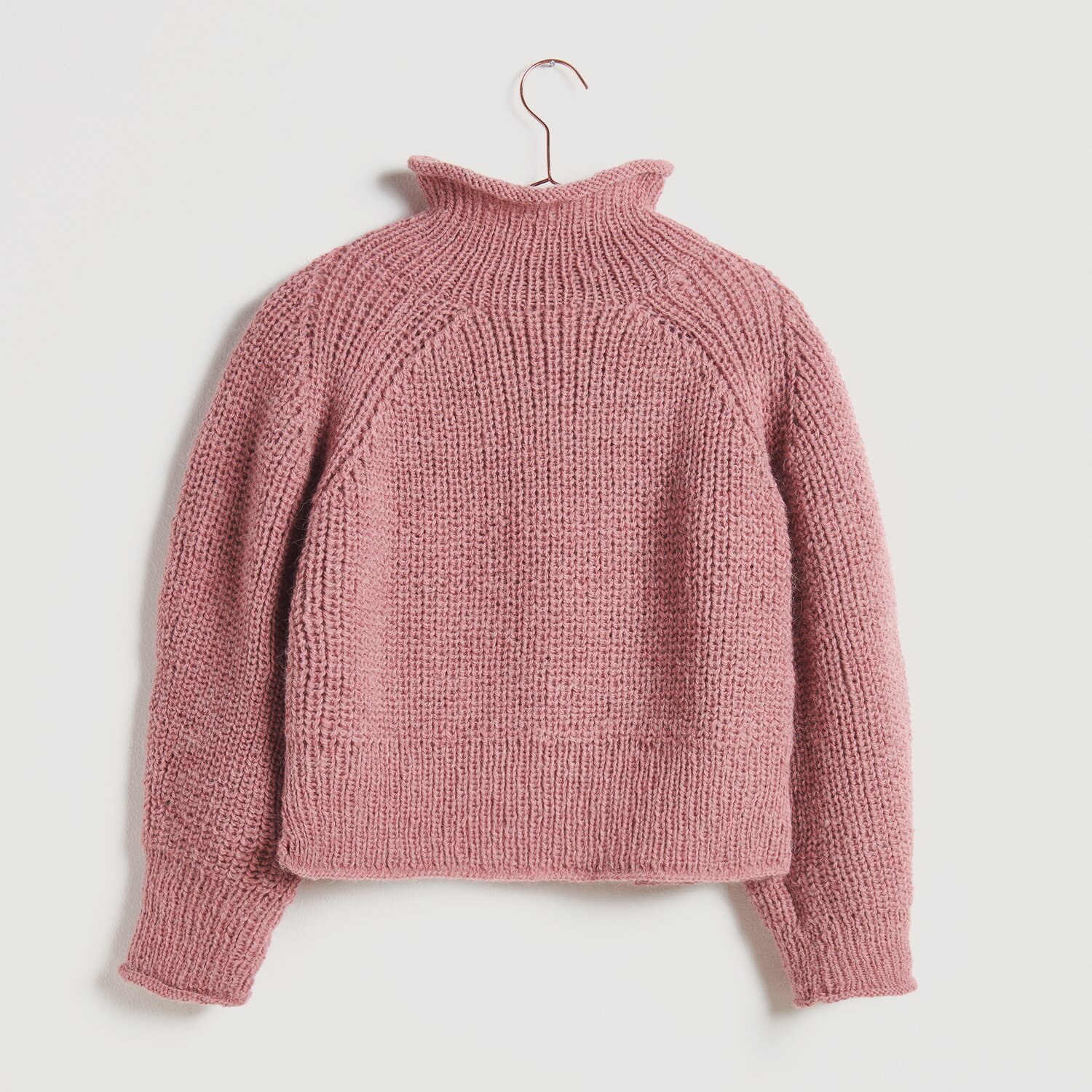 Strickset Pullover Modell 16 in Rosa, gestrickter Pullover mit hohem Kragen auf einem Kleiderbügel.