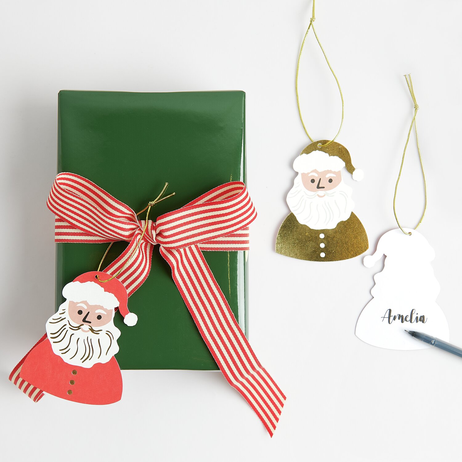 Paper Poetry Geschenkanhänger Weihnachtsmann, 8-teilig, mit grünem Geschenk und roter Schleife.