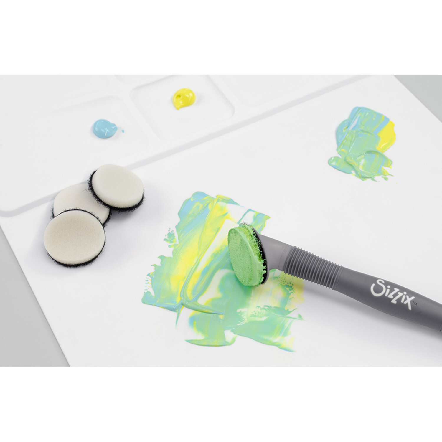 Studio Multi Tool Accessory Blending Tool Sponge Head von Sizzix auf weißem Papier mit bunten Farbmischungen.