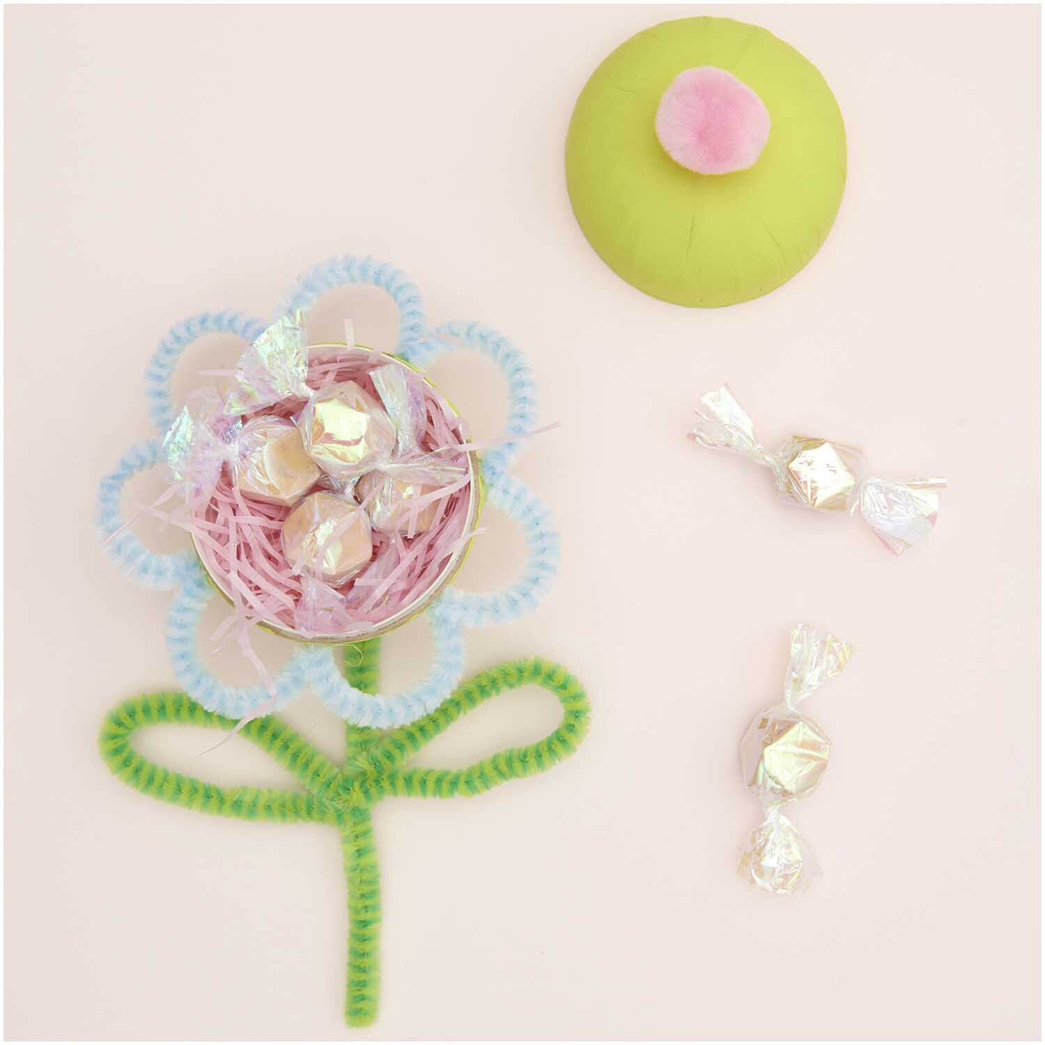 Chenilledraht-Mix 50cm 10 Stück Streifen Mix: Bunte Chenilledrähte formen eine Blume mit Süßigkeiten auf hellem Hintergrund. Ideal für kreative Bastelprojekte.