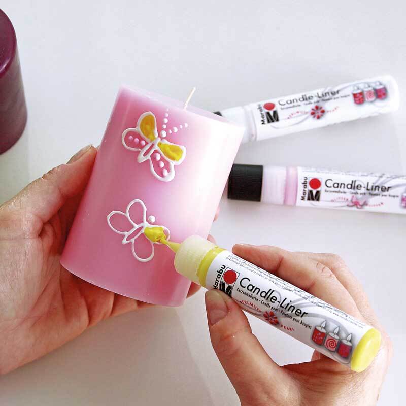Candle Liner 25ml: Eine rosa Kerze wird mit einem gelben Marabu Liner verziert. Im Hintergrund sind weitere Liner zu sehen.