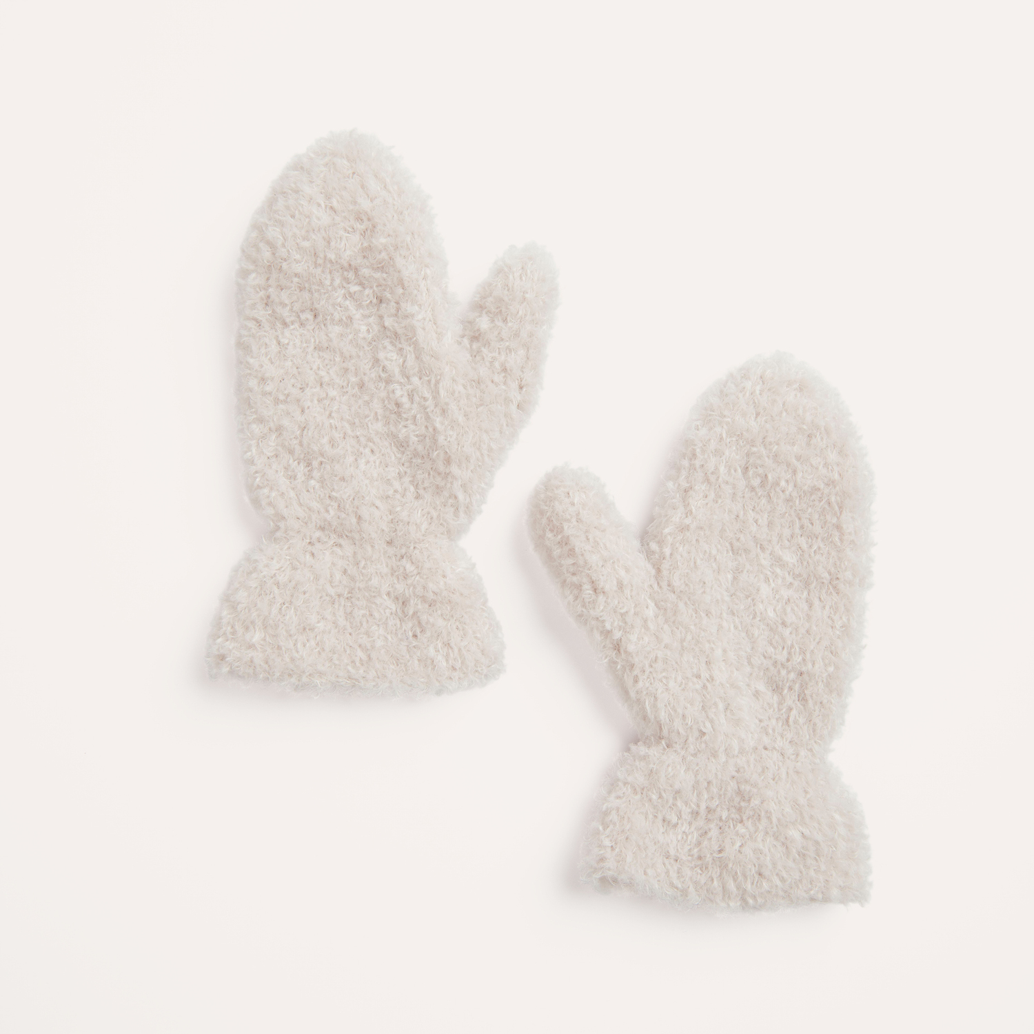 Strickanleitung Kuschelige Fäustlinge aus Creative Teddy: Flauschige, cremefarbene Fäustlinge auf hellem Hintergrund.