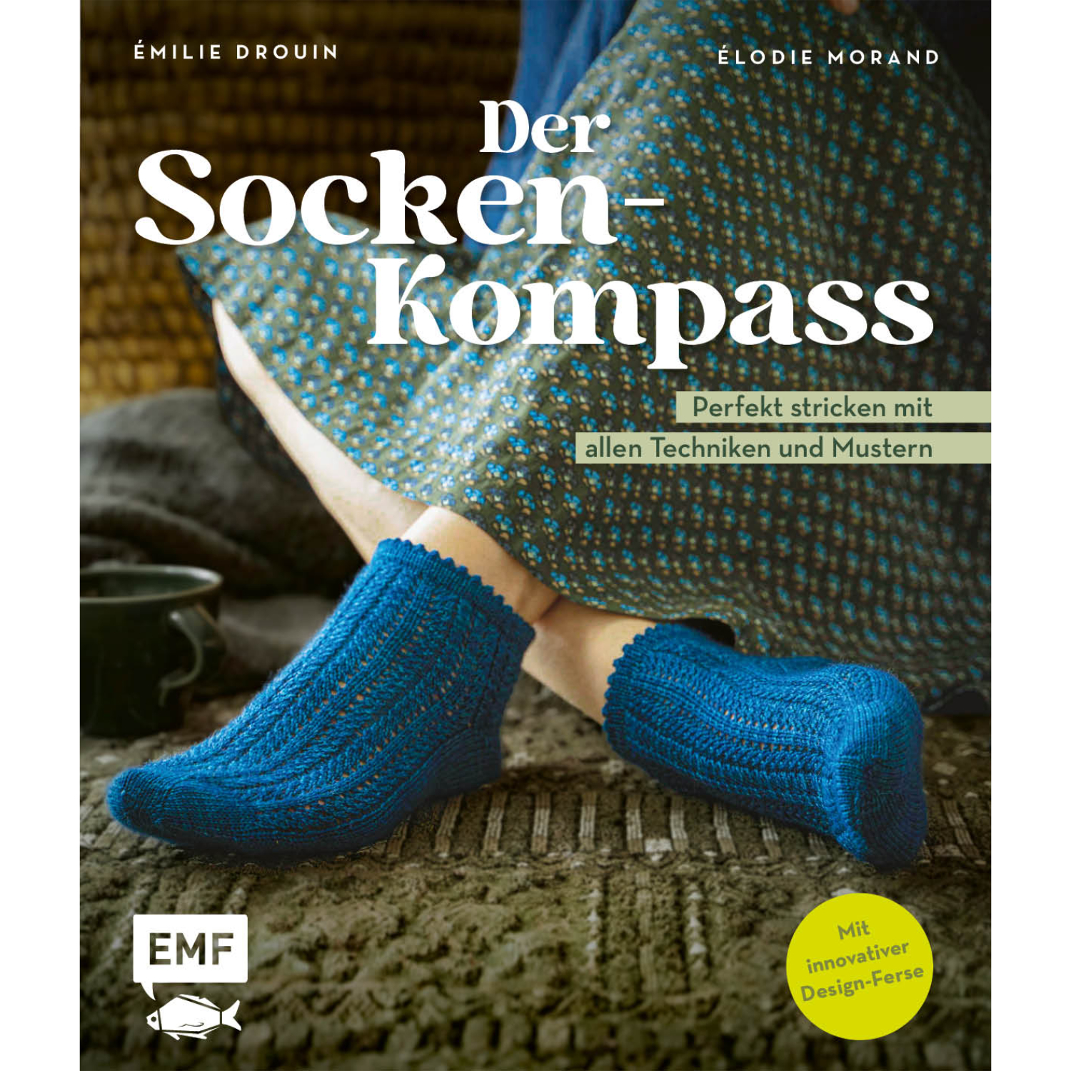 Der Sockenkompass zeigt blaue gestrickte Socken auf einem Holzboden. Perfekt stricken mit allen Techniken und Mustern. Marke: EMF.