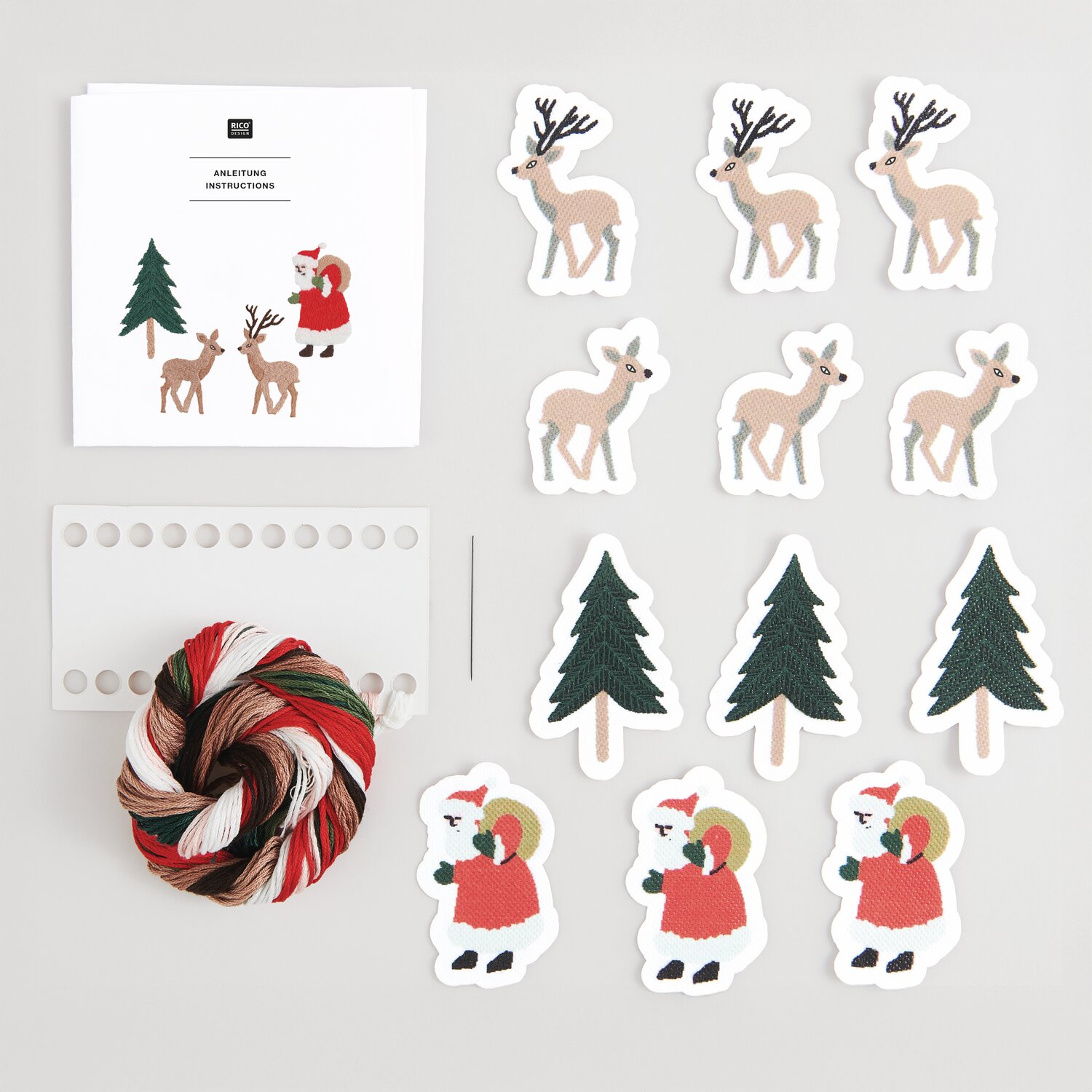 Stick & Stitch Stickpackung Weihnachtswald 12 Stück mit Rentieren, Bäumen und Weihnachtsmann. Enthält Garn in Rot, Grün und Weiß.