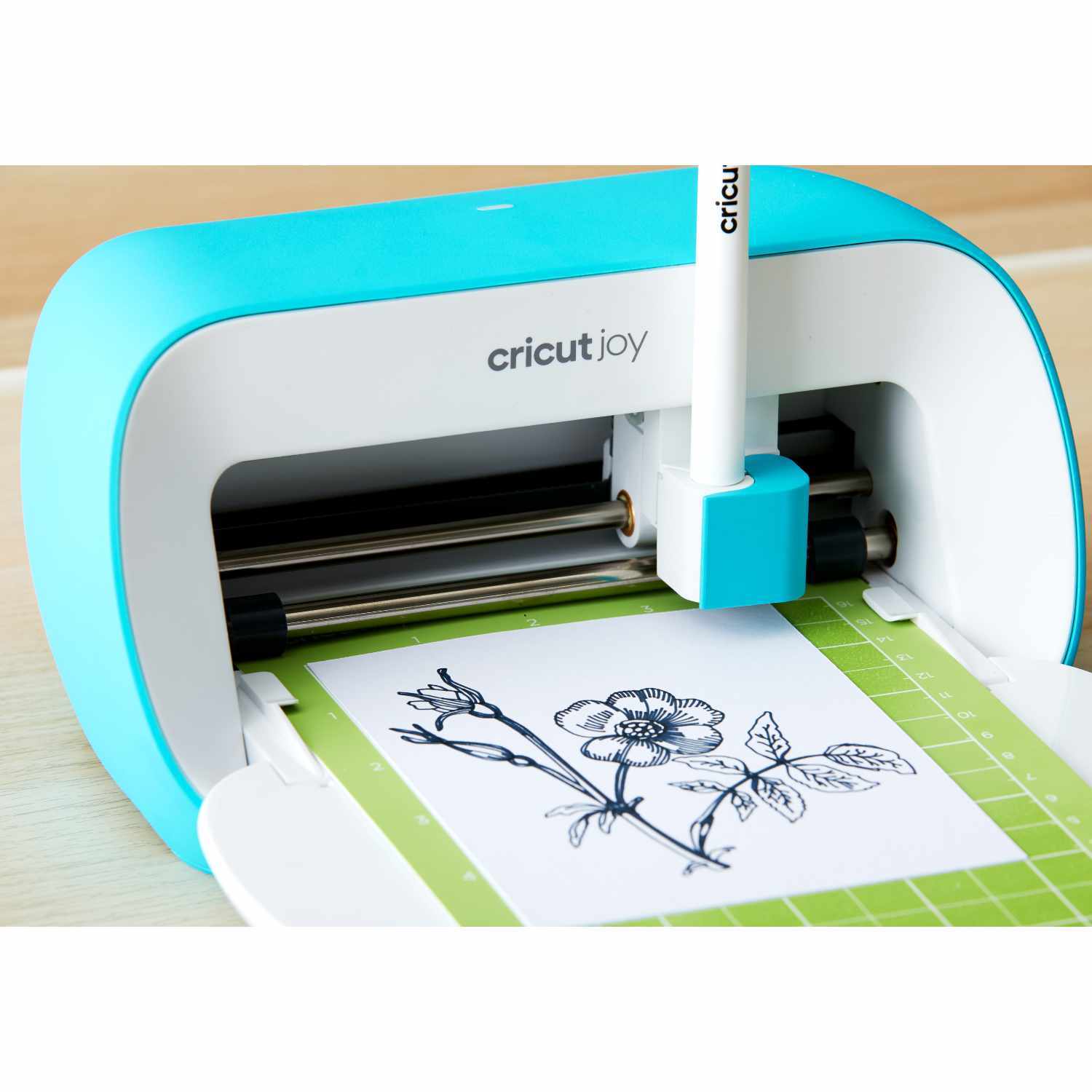 Joy Schneideplotter von Cricut in Aktion, schneidet präzise ein Blumenmotiv auf weißem Papier.
