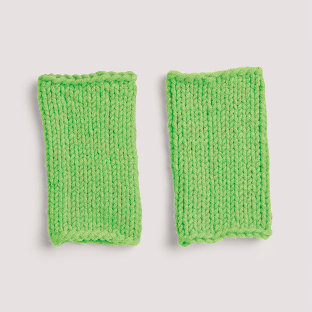 Stulpen neongrün auf grauem Hintergrund – zum Strickset