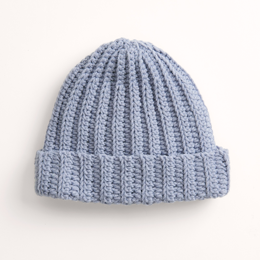 Blaue Mütze auf grauem Hintergrund – zum Strickset