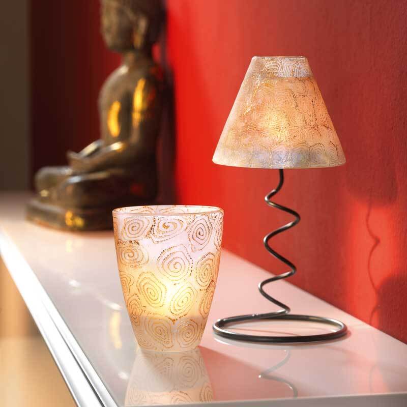 FIMO effect: Elegante Tischlampe und Kerzenhalter auf weißem Regal vor roter Wand, Buddha-Statue im Hintergrund.