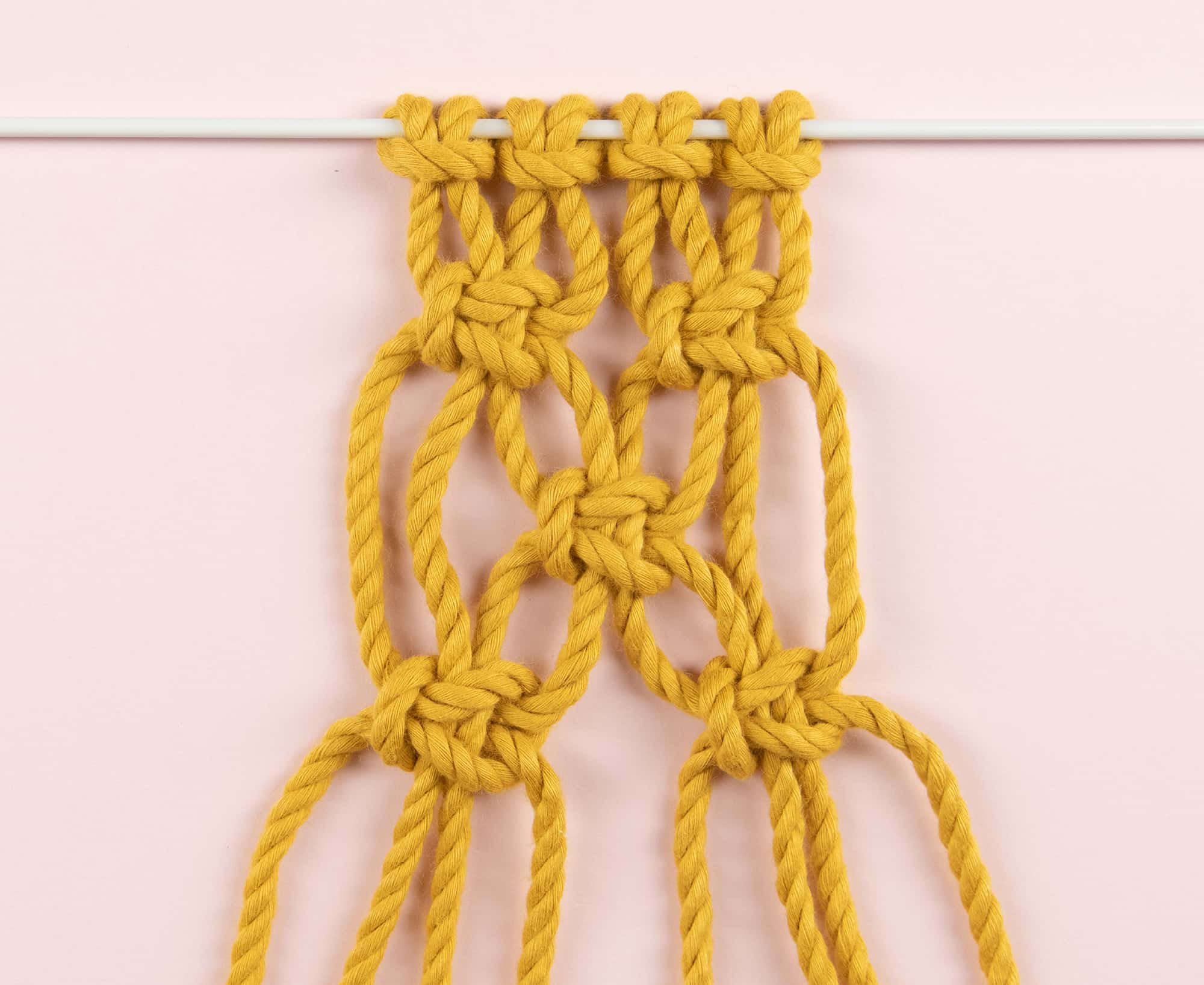 Makramee Kreuzknoten-Muster aus gelbem Makramee Garn