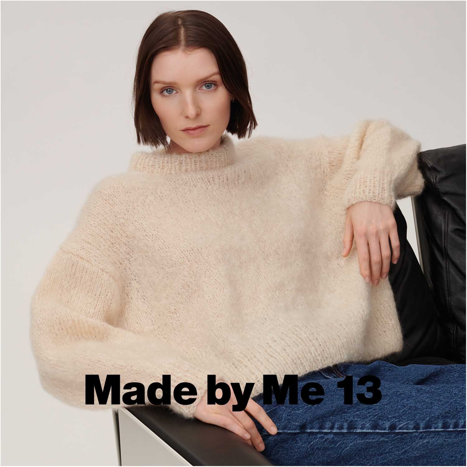 Essentials Super Chunky Pullover in Natur von Rico Design, getragen von einer Frau auf einem Sofa.