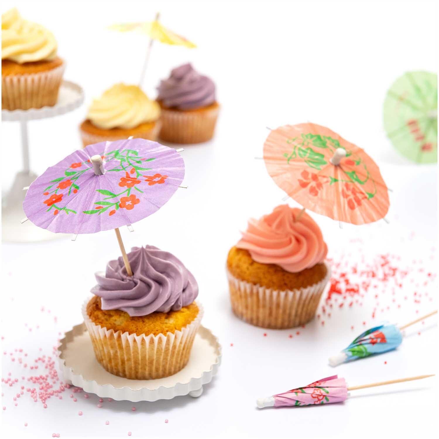 Picker Schirmchen floral 8,3cm 12 Stück von Rico Design auf Cupcakes mit buntem Zuckerguss und Streuseln.