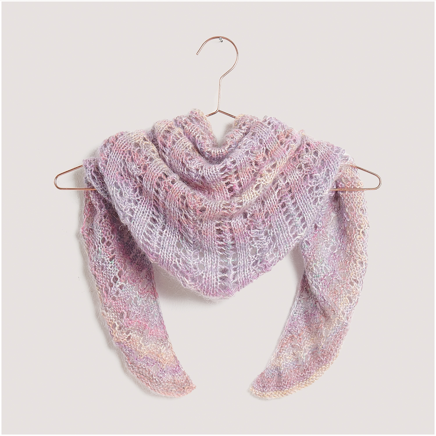 Strickset Tuch Modell 13 aus Lovewool Nr. 18: Ein zartes, pastellfarbenes Tuch auf einem Kleiderbügel drapiert.