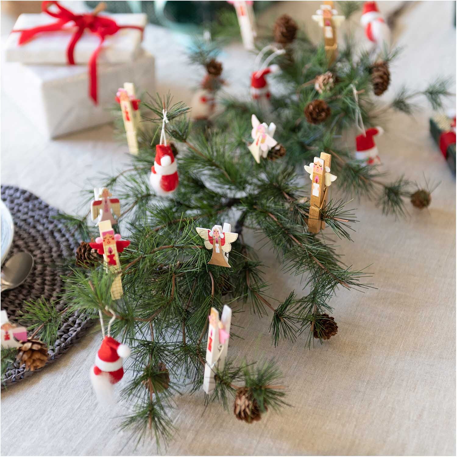 Dekoklammern Engel 3,5cm 4 Stück von Rico Design an einem Tannenzweig mit Weihnachtsdekoration.