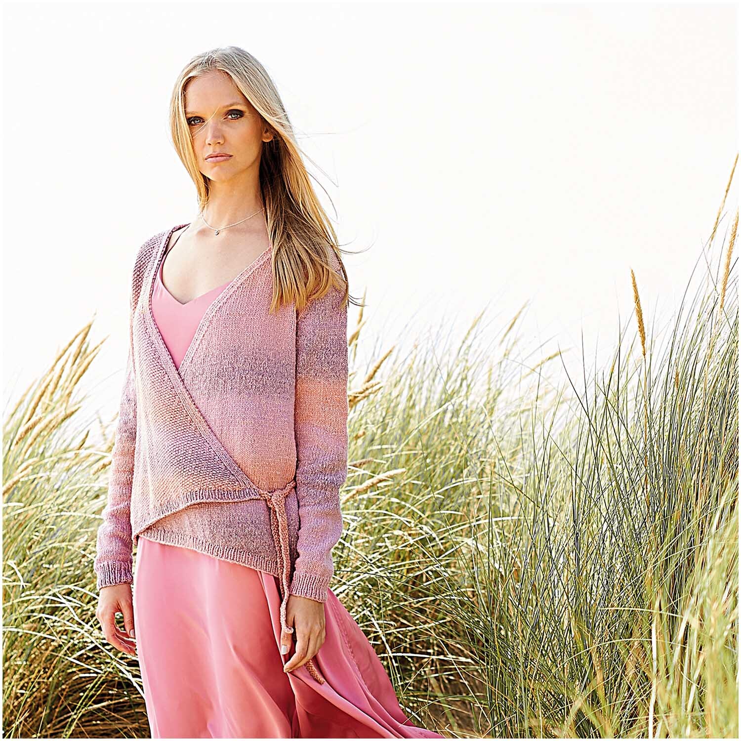 Fashion Cotton Light & Long dk: Frau in rosa Strickjacke von Rico Design, stehend in Dünen.