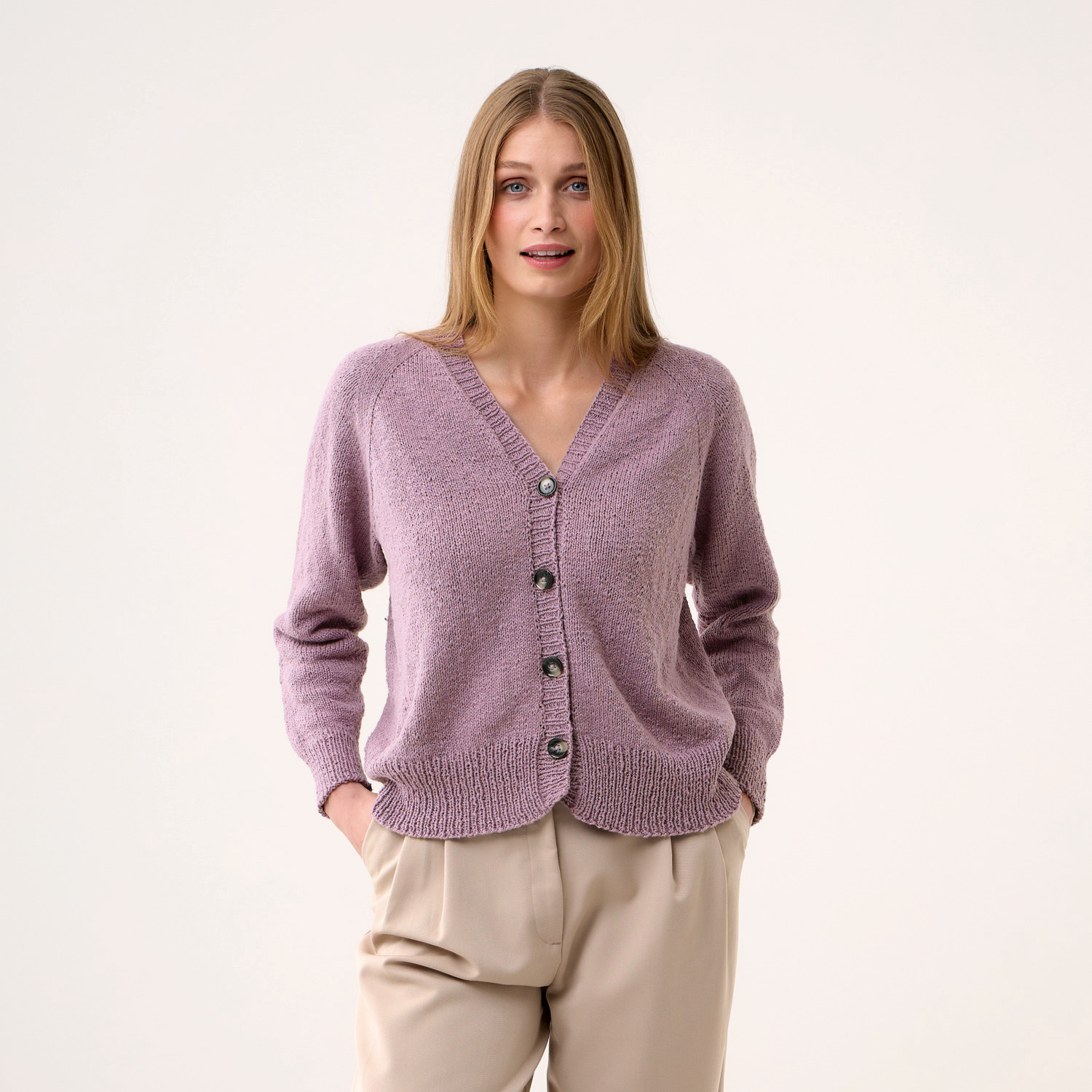 Strickset Cardigan Modell 10, lila, mit Knopfleiste, kombiniert mit beigen Hosen. Ideal für kühle Tage.