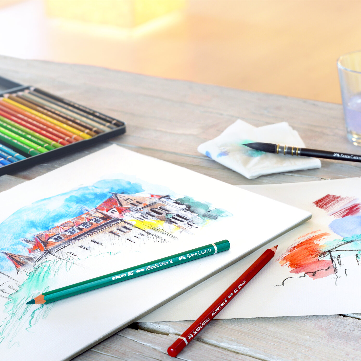 Albrecht Dürer Aquarellstift auf einem Tisch mit Skizzen und Faber Castell Stiften in verschiedenen Farben.