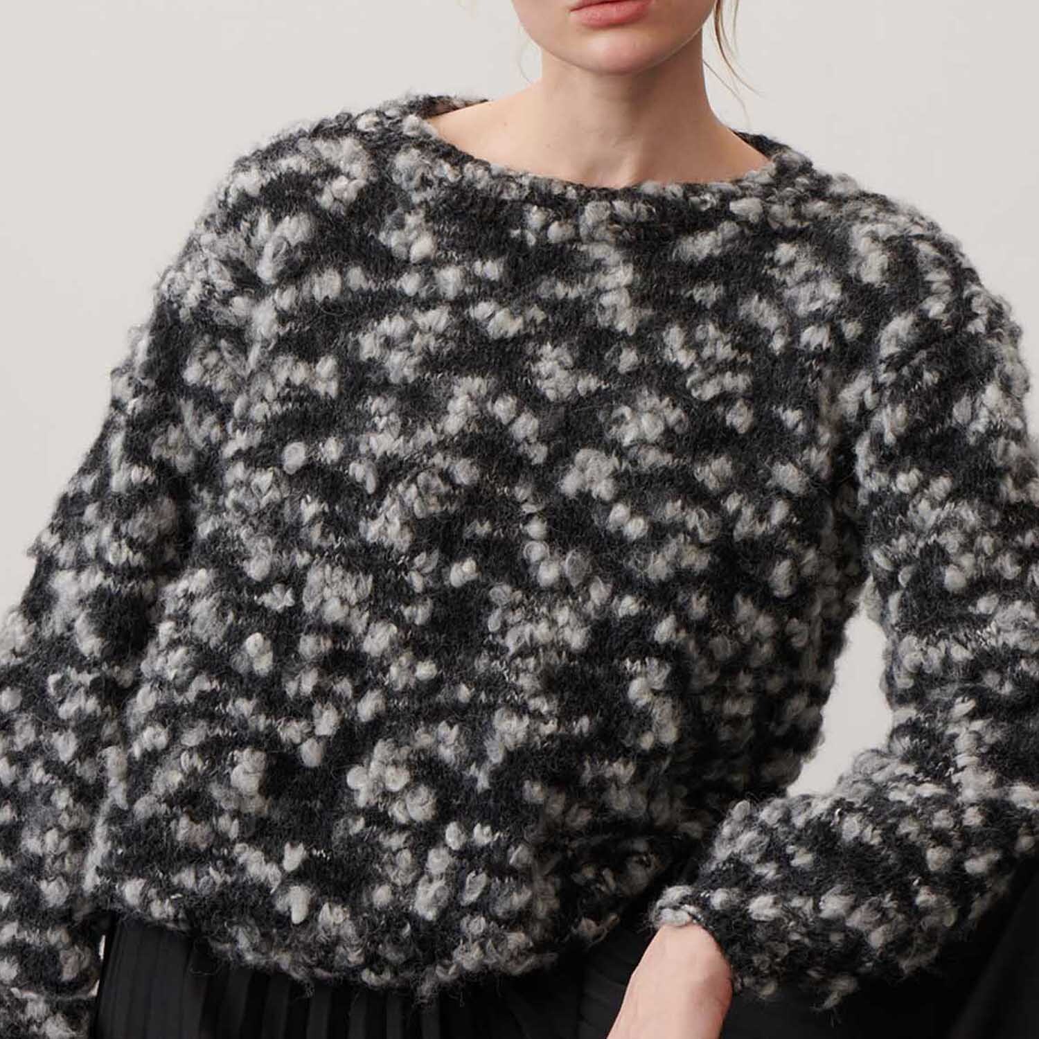 Fashion Alpaca Vibes aran Pullover aus weichem Garn in Schwarz-Weiß von Rico Design, getragen von einer Person.