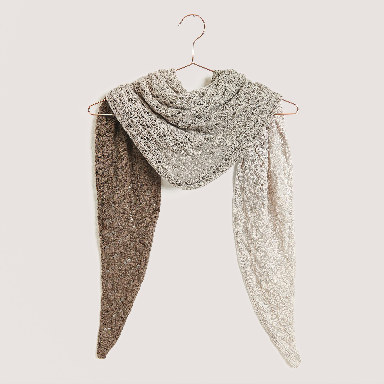 Creative Cotton Dégradé Lucky 8: Dreifarbiger Schal in Naturtönen, gehäkelt, auf einem Kleiderbügel präsentiert.
