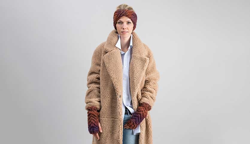 Strickanleitung Stirnband und Stulpen aus Creative Ito Iro chunky: Frau trägt braunen Mantel mit passendem Stirnband und Stulpen.