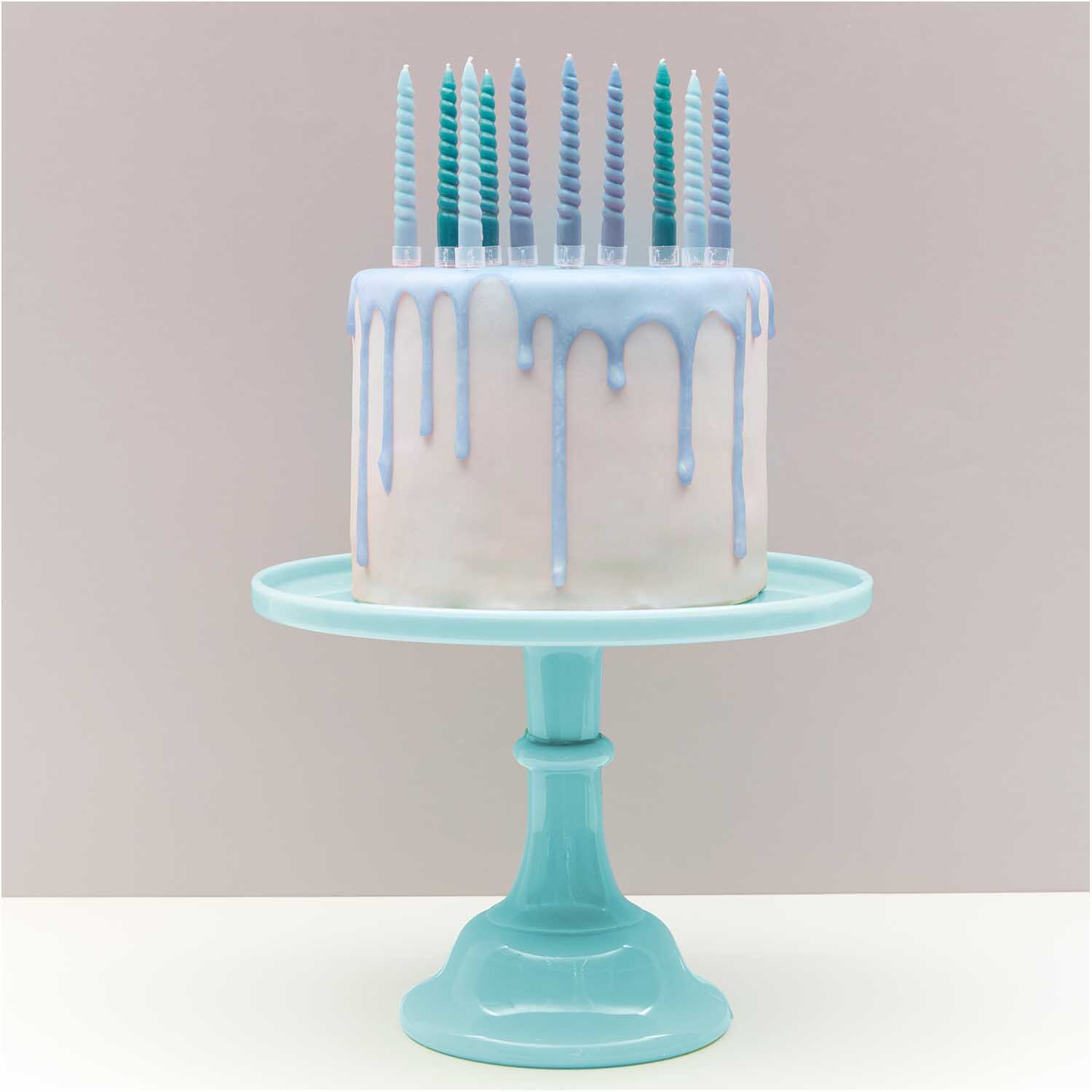 Spiralkerzen smokey blau Mix 1,2x10cm 10 Stück auf einer Torte mit blauem Drip-Effekt.