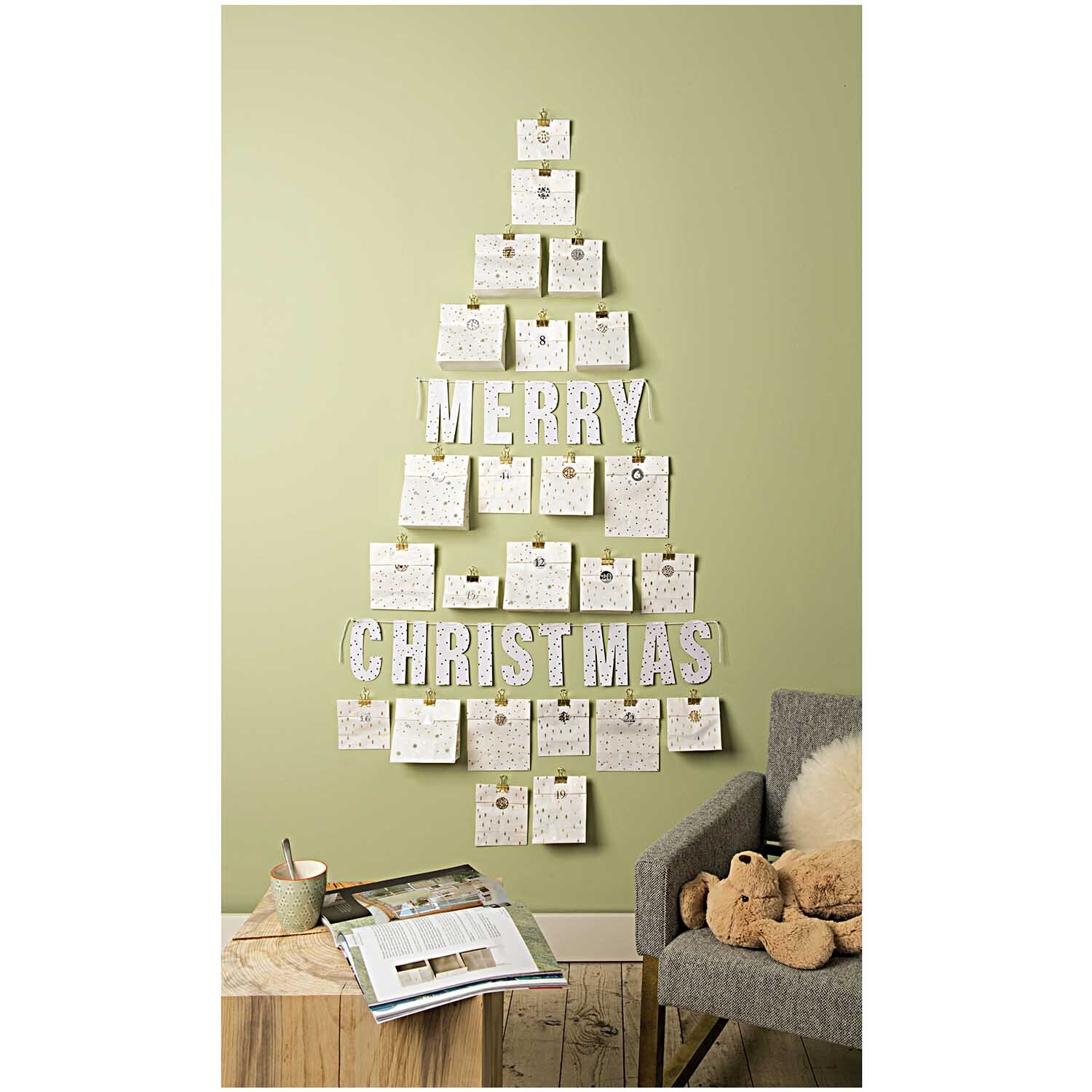 Paper Poetry Foldback Klammern in Gold, dekorativ an einer Wand in Form eines Weihnachtsbaums arrangiert.